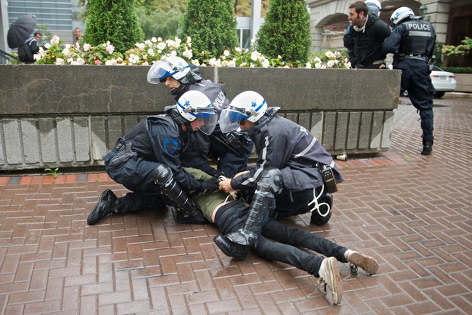 A man is pinned down on the floor by policemen 